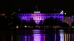 Das Hotel Atlantic ist im Dunkeln anlässlich des Weltmädchentages pink beleuchtet.