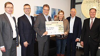 Das Management von arvato Financial Solutions überreicht einen Scheck in Höhe von 30.000 Euro an Plan International Deutschland e.V.- v.l. Volker Bornhöft, Frank Kebsch, Michael Weinreich, Angela Bergel (Plan), Marco Jostes, Rudolf Gellrich