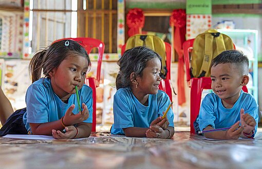 Drei Kinder in einem Hort in Kambodscha