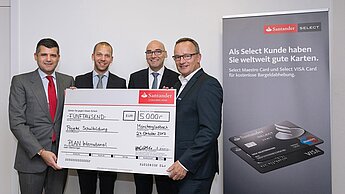 Fernando Silva, Generalbevollmächtigter & Leiter Retail Santander Bank, Matthias Ruddat, Leiter Santander Select und Dieter Krohe, Leiter Vertrieb Retail überreichen den Scheck an Wolfgang Porschen, Geschäftsführer Marketing & Fundraising Plan International Deutschland e.V.