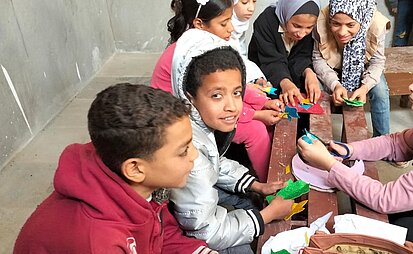 Ein Junge bastelt gemeinsam mit anderen Kindern