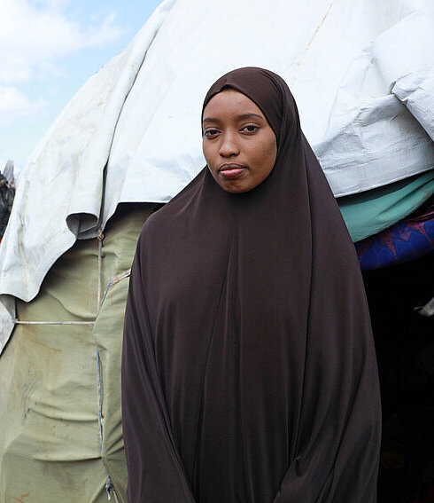 Munira steht vor ihrem Zelt im IDP-Camp in Baidoa