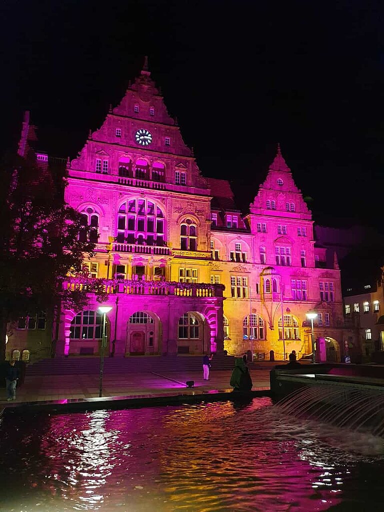Das bielefelder Rathaus ist pink erleuchtet.