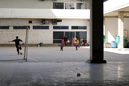 Kinder spielen in einer Notunterkunft Fußball