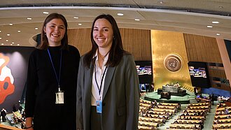 Zwei junge Frauen stehen vor dem Saal der UN-Generalversammlung