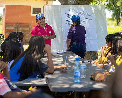 Mädchen aus der Gemeinde in Paraguay nehmen draußen an einem Plan-workshop teil