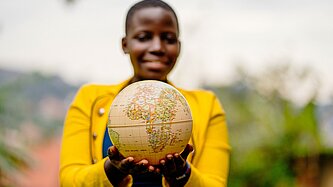 Ein Junge hält einen Globus in der Hand