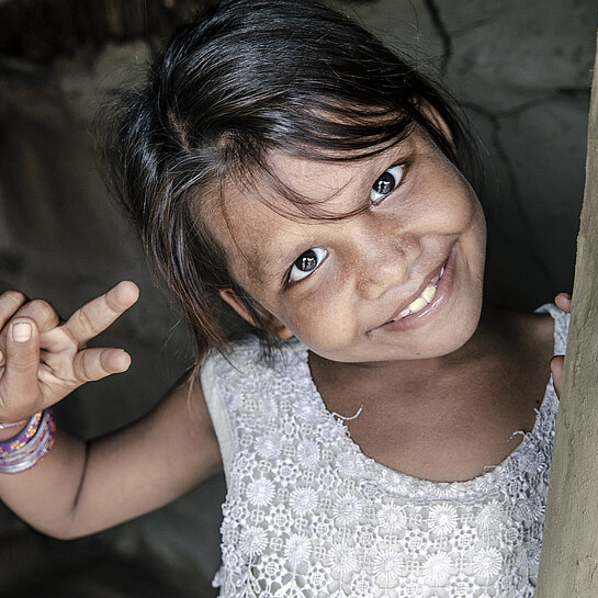 Bhumika zeigt mit der Hand ein Peace-Zeichen.