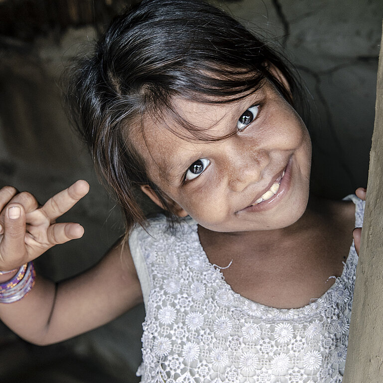 Bhumika zeigt mit der Hand ein Peace-Zeichen.