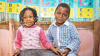 Mädchen und Junge schreiben auf einer Tafel