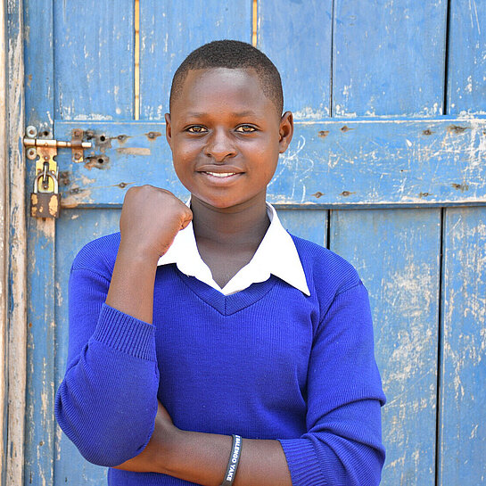 Die 14-jährige Hellen in Tansania steht vor einer Eingangstür