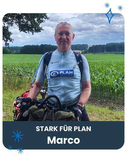 Marco steht vor einem Feld mit diesem Fahrrad. Er trägt ein Radler-Shirt mit Plan-Logo.