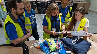 Mitarbeitende von Plan International begutachten ein Dignity Kit