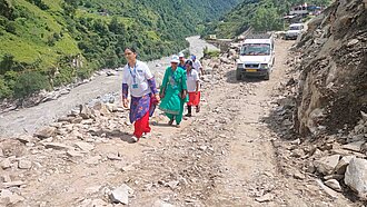 Auf einer Straße voller Geröll laufen mehrere Personen