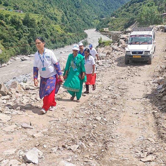 Auf einer Straße voller Geröll laufen mehrere Personen