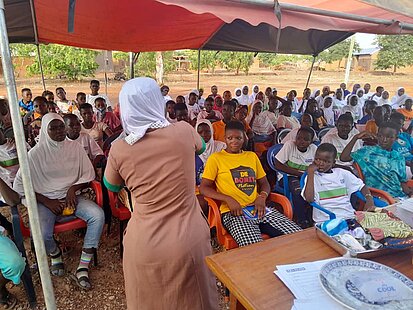 Junge Menschen hören dem Vortrag einer Frau zu