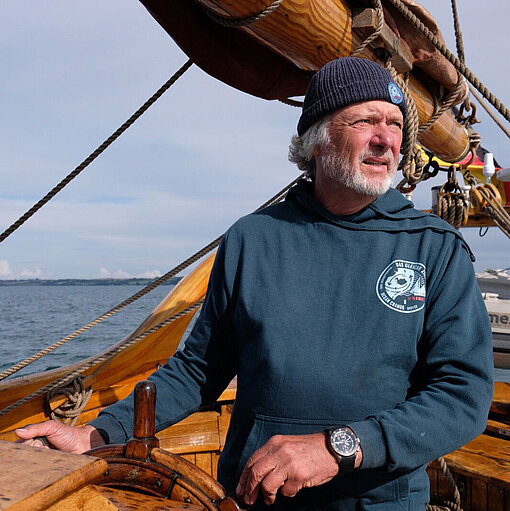 Polarforscher Arved Fuchs steuert ein Segelschiff auf Expedition zur Klimaforschung.