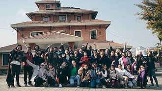 Bild: Eine Gruppe Jugendlicher posiert vor einer Schule in Nepal