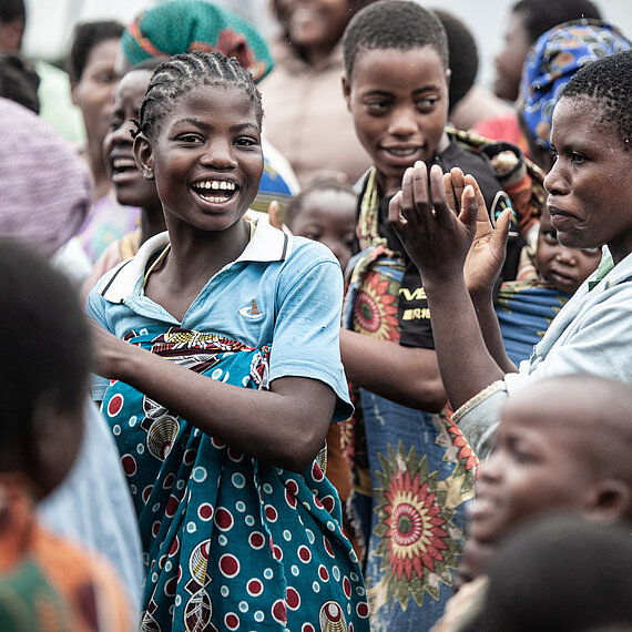 Mädchen und Frauen tanzen und lachen bei einer Gemeinschaftsveranstaltung in Malawi