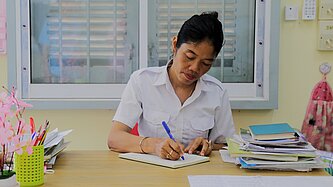 Kimhuch macht sich an ihrem Schreibtisch Notizen