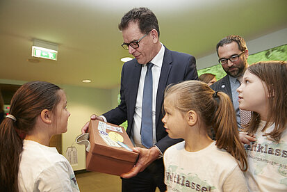 Drei Schülerinnen der Grundschule am Teutoburger Platz in Berlin übergeben ihre Botschaften an Entwicklungsminister Gerd Müller im BMZ (©Mike Auerbach)