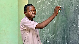 Ein junger Mann steht an einer Tafel