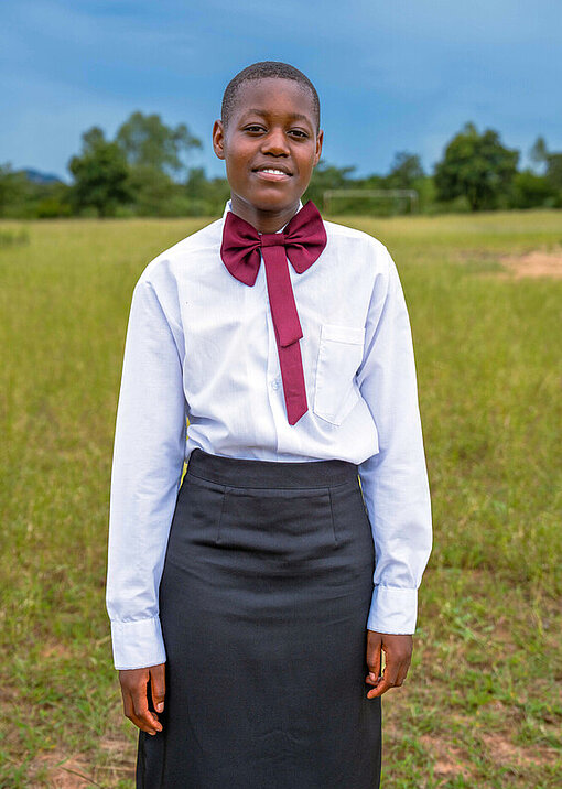 Evelyn steht in ihrer ländlichen Gemeinde in Manicaland, Simbabwe
