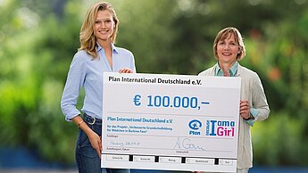 Das international bekannte Model Toni Garrn übergibt einen Scheck an Plan-Geschäftsführerin Maike Röttger © Morris Mac Matzen/Plan