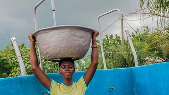 Eine junge Frau sammelt Wasser.