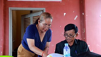 Sohen und ein Kollege lesen einen Bericht zum Thema Kinderschutz und besprechen diesen