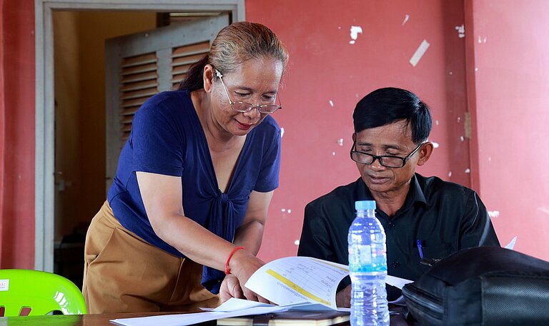 Sohen und ein Kollege lesen einen Bericht zum Thema Kinderschutz und besprechen diesen