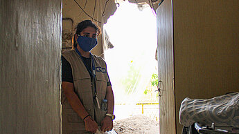Eine Plan-Mitarbeiterin steht in einer von der Explosion zerstörten Wohnung. ©Plan International