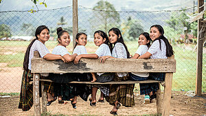 Guatemaltekische Mädchen bei einer Leadership-Initiative. Guatemaltekische Mädchen sitzen lachend auf einer Bank bei einer Leadership-Initiative.