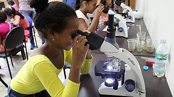 Mädchen an die Mikroskope: Ein Projekt will junge Frauen für Wissenschaft und Technik begeistern. © Plan International