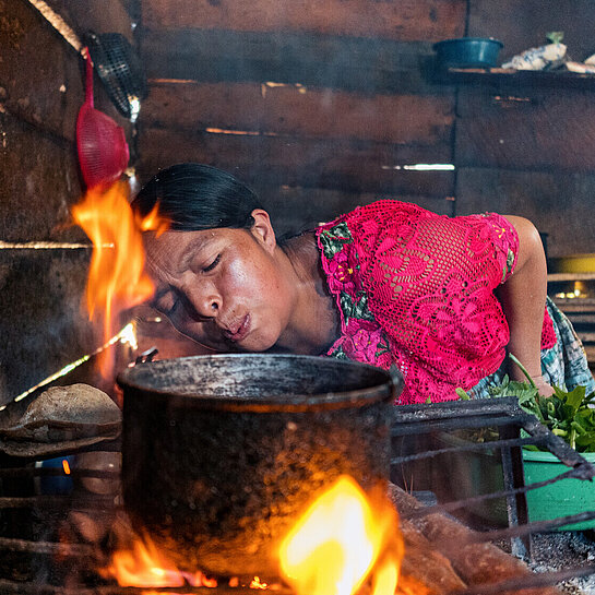 Eine Frau in Guatemala macht Feuer und kocht Essen