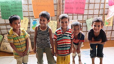 Vier Kleinkinder stehen in einer Reihe