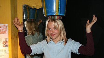 Einen Eimer Wasser transportieren wie in der Sahelzone - erlebbar in der interaktiven Schau.