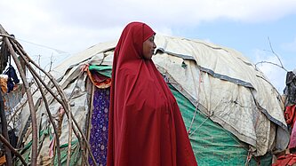 Hibo steht vor ihrem Zelt im IDP Camp