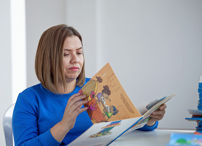 Eine Frau blättert in einem Buch