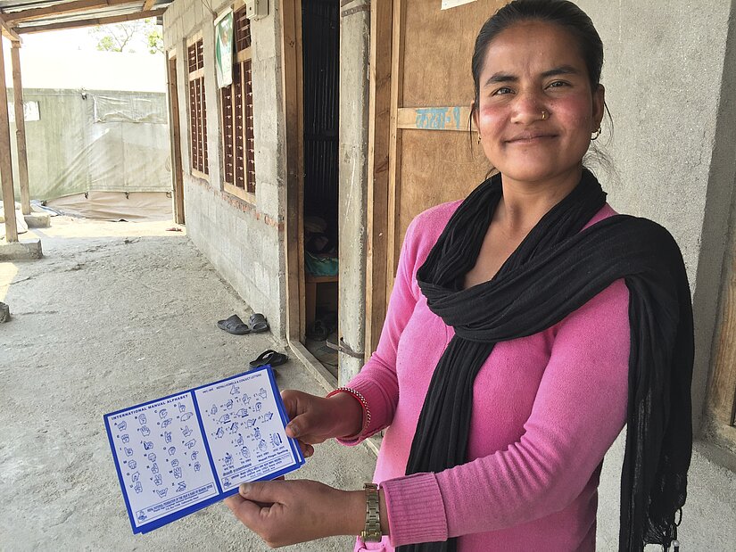 Head teachers Bidhaya shows the sign language card that teaches students how to sign Head teachers Bidhaya shows the sign language card that teaches students how to sign