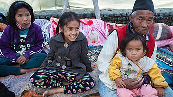Eine Familie lebt in einer Notunterkunft in der Gemeinde Boudhanath in Nepal © Guido Dingemans/Plan