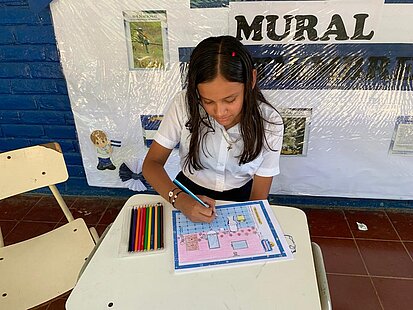 Ein Mädchen malt die Zeichnung eines Badezimmers aus