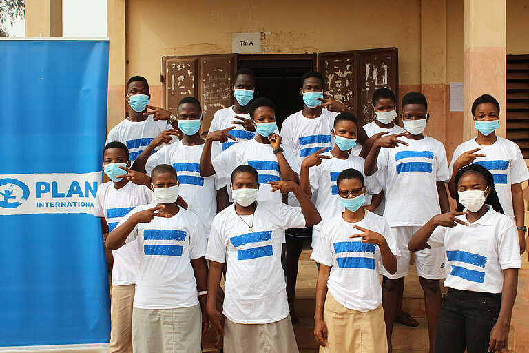Gruppe von Jungen mit OP-Masken und Plan T-shirts.