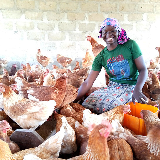 Mädchen umgeben von ihren Hühnern.