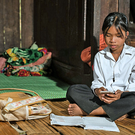 Ein junges Mädchen sitzt auf einer Matte
