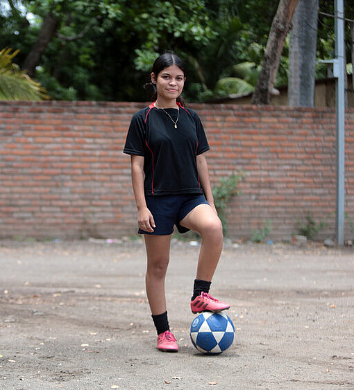 Saidia steht auf dem Platz und legt ihren Fuß auf den Ball ab