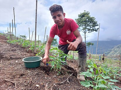 Ein Jugendlicher arbeitet auf einem Feld