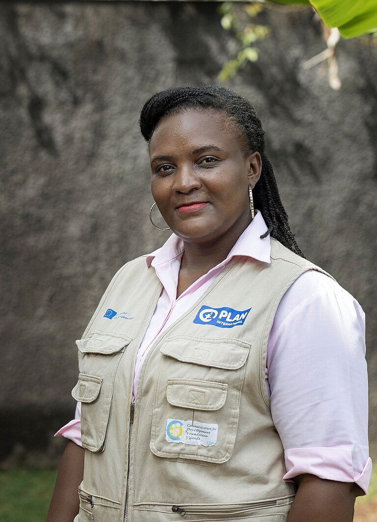 Christine steht draußen in der Gemeinde in Uganda