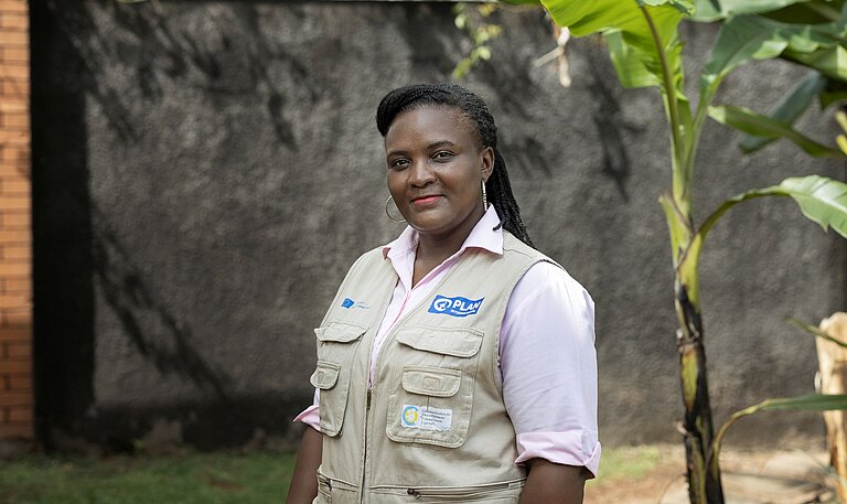 Christine steht draußen in der Gemeinde in Uganda