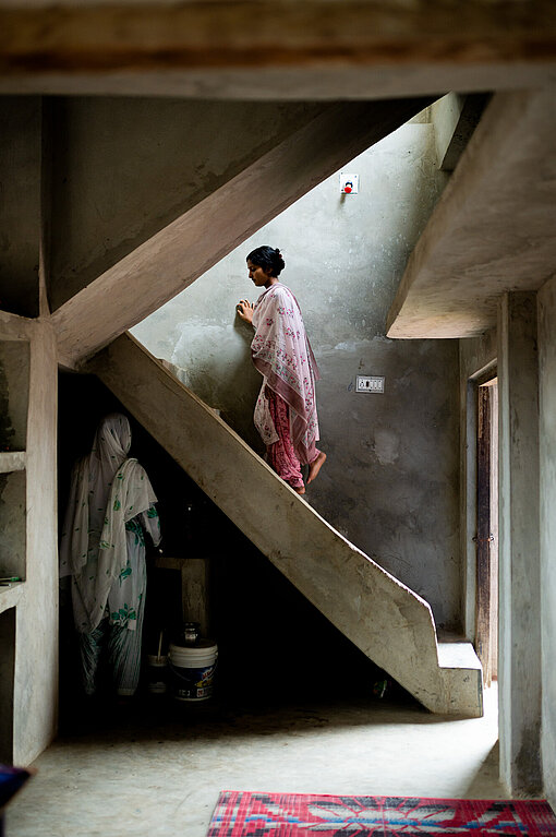 Eine junge Frau geht eine Treppe in einem Haus hinauf